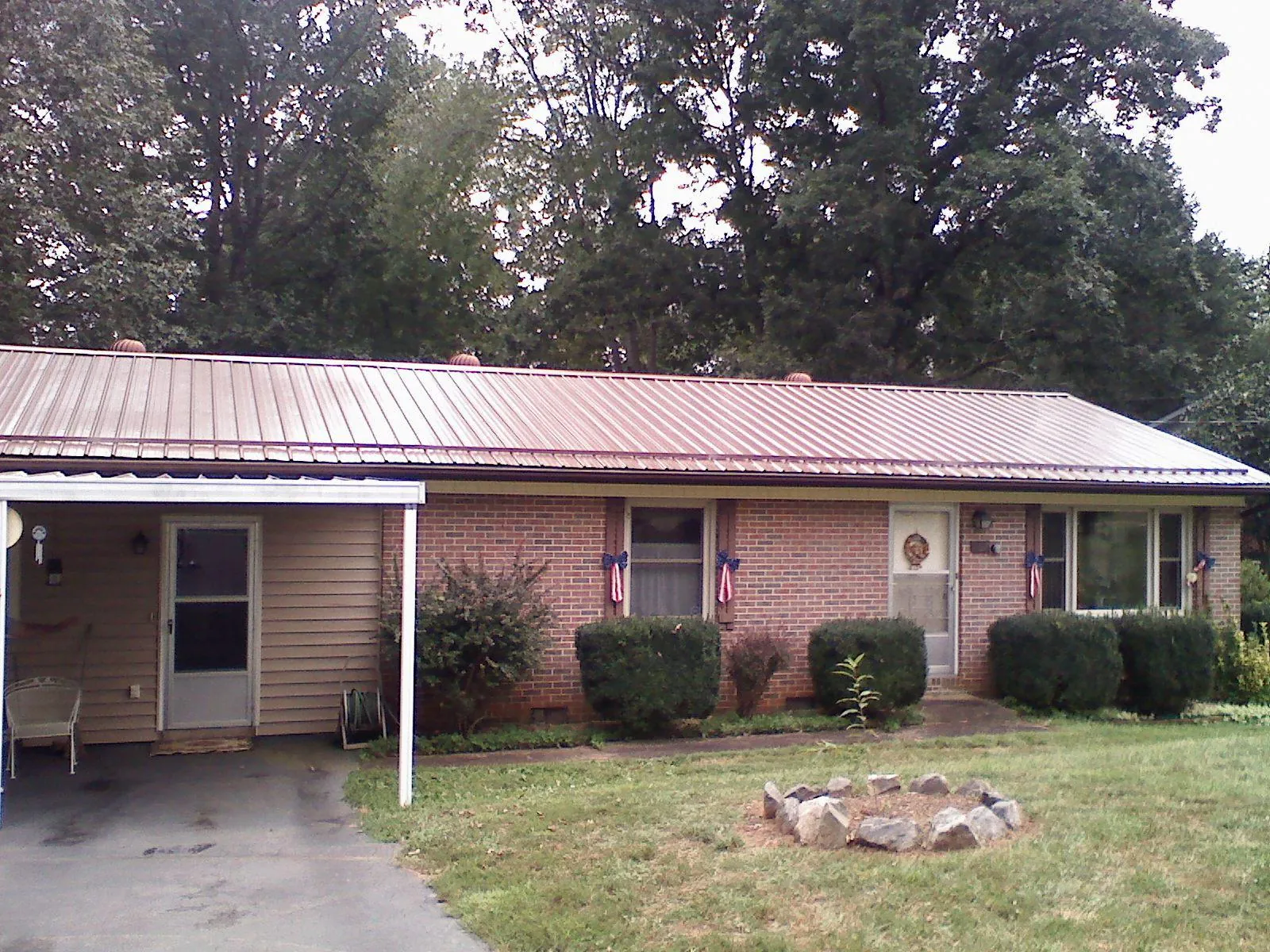 Bronze metal roof and carport on a brick ranch home — Roof Repair work by our crew in Williamsburg